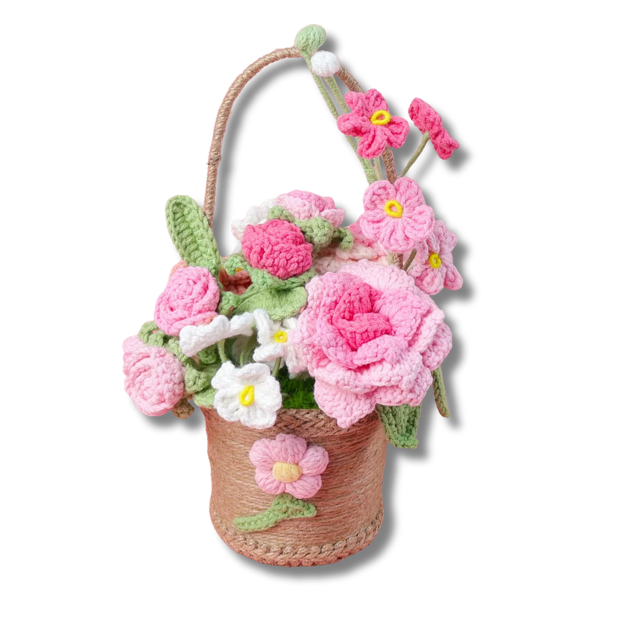 Gehäkelter Geschenkkorb mit rosa und weißen Blumen in einem dekorativen Korb